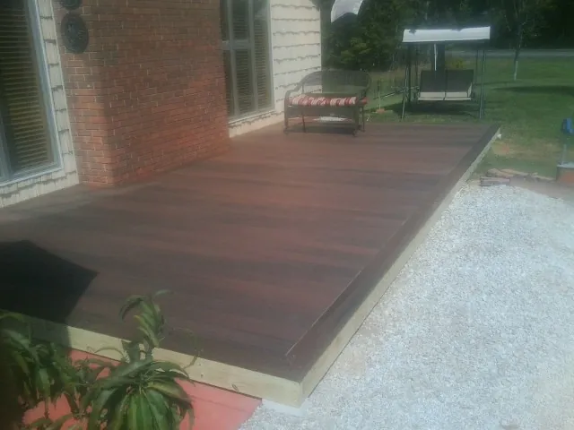 Freshly stained wood deck built against a brick home in Charlestown